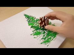 someone is using green crayon to decorate pine cones on a piece of paper