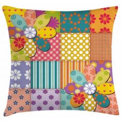 a colorful patchwork pillow with flowers and butterflies on the front, in multicolored squares