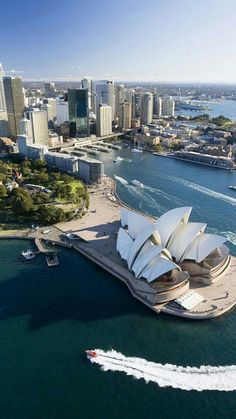 an aerial view of the sydney opera house and surrounding cityscape, with boats in the water