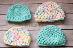 three crocheted hats are shown on a wooden surface