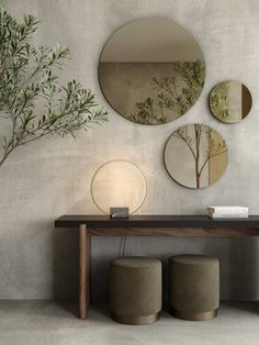 three circular mirrors on the wall above a table