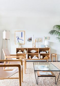 a living room filled with furniture and a plant in the corner on top of a coffee table