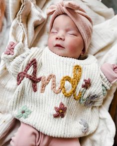 Personalized Embroidered Name Sweater Kids -- Hand Embroidered Sweater  These hand embroidered name sweaters are just what you need for your littles! Sizes 0-6m to 3T (3T is large and can fit up to a 6 year old!) The sweaters listed tend to be oversized. Please size down one size if you would like it more fitted.  100% Organic Cotton NOTE: the Camel sweaters are not as oversized, and are more of a fitted sweater.  PLEASE NOTE: If you do not leave your yarn color choice in the customizable box wi Baby Name Sweater Knit, White Long Sleeve Sweater With Floral Applique, Cute Cotton Sweater With Floral Embroidery, Cute Sweater With Letter Embroidery For Fall, Cute Letter Embroidery Sweater For Fall, Knit Name Sweater, Name Sweater Baby, Embroidered Name Sweater, Hand Embroidered Sweater