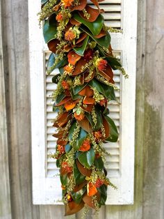 an image of a plant hanging from the side of a building with leaves and flowers on it