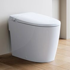 a white toilet sitting on top of a hard wood floor next to a wall and window