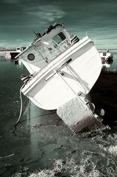 an old boat sitting on top of the water