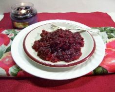 a white plate topped with cranberry sauce on top of a red place mat