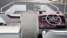 the interior of a boat with seats and steering wheel