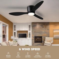 the ceiling fan is black and has six blades on it, which are mounted in front of a fireplace