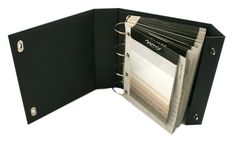 a black binder is open on top of a white background with papers in it