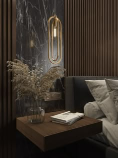 a table with a book and some plants on it in front of a wall that has wood slats