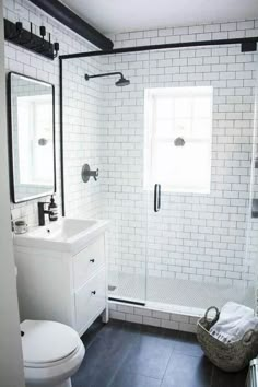 a bathroom with black and white tile flooring, a sink, toilet and shower