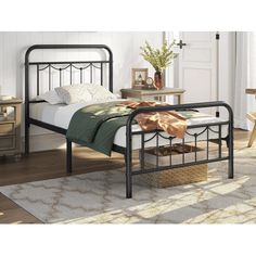 a metal bed frame in a bedroom with white walls and wood floors, along with a rug on the floor