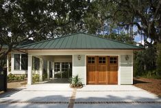 a garage with a green roof surrounded by trees