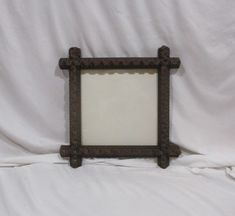 a brown frame sitting on top of a white sheet