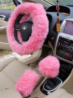 the interior of a car with pink fuzzy steering wheel covers