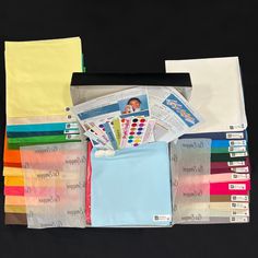 an assortment of color samples and papers on a black background