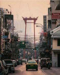 cars are driving down the street in front of tall buildings and power lines above them