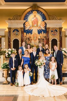 a wedding party poses for a photo in front of the alter at st mary's church