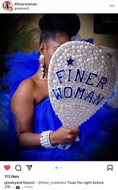 a woman holding a heart shaped pillow with the words finer woman on it