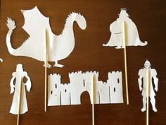 some paper cut out of different types of people and animals on sticks with toothpicks in front of them