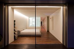 a bedroom with a bed and wooden flooring in the middle of an open room