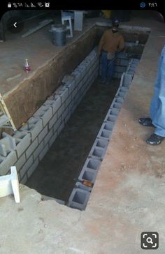 a man standing next to a brick wall under construction