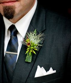 a man wearing a suit and tie with a boutonniere on his lapel