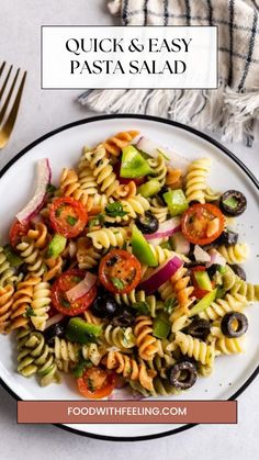 a white plate topped with pasta salad next to a fork