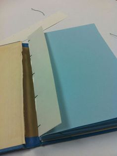 three different colors of paper sitting on top of a white table next to each other