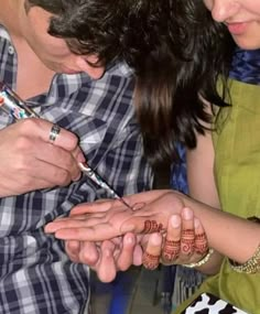 a man and woman standing next to each other with their hands on one another's fingers