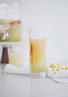 a glass filled with liquid sitting on top of a table next to a white napkin