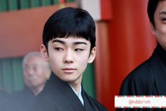 two men in black robes standing next to each other and one is looking at the camera