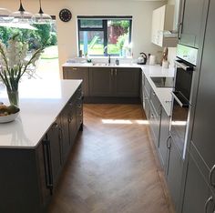 a large kitchen with stainless steel appliances and wood flooring is pictured in this image