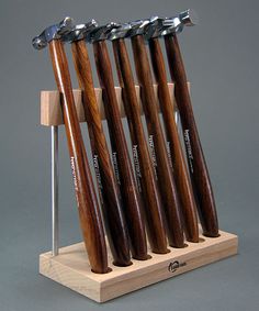 a set of six wooden knives on display with metal blades in the middle and wood handles at each end