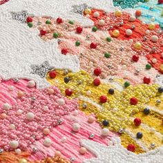 a close up view of an art quilt made with beads and other things on it