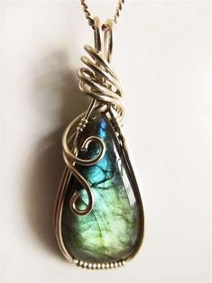 a wire wrapped pendant with a green and blue tear