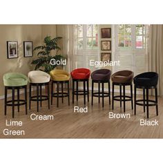 a set of six stools with different colors and sizes in front of a window