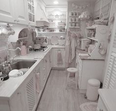 a black and white photo of a kitchen with lots of clutter on the counter