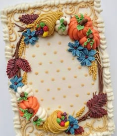 a decorated cake with white frosting and fall decorations on it's edges, sitting in front of a white background