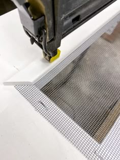 a piece of metal being worked on by a machine that is cutting through the mesh