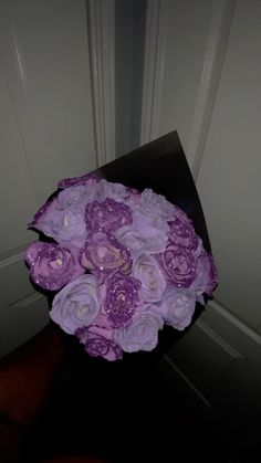 a bouquet of purple flowers sitting on top of a black table next to a door