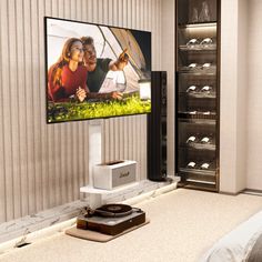 a flat screen tv mounted to the side of a wall next to a bed in a bedroom