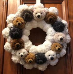 a wreath with teddy bears on it hanging from the front door to be hung up