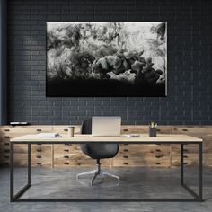 a black and white photo hanging on the wall above a desk