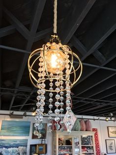 a chandelier hanging from the ceiling in a room with pictures on the walls