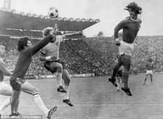 an old black and white photo of two soccer players jumping up to head the ball