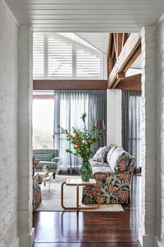 a living room with white brick walls and wooden floors