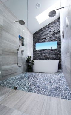 a bathroom with a large white tub sitting next to a walk in shower under a skylight