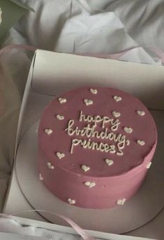 a pink birthday cake in a box with white hearts on the top and writing happy birthday princess